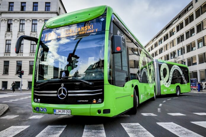 przegubowy autobus Mercedes-Benz eCitaro G fuel cell w zielonym malowaniu przewoźnika LPP, pod zadaszeniem stacji tankowania wodoru Energetika Ljubljana
